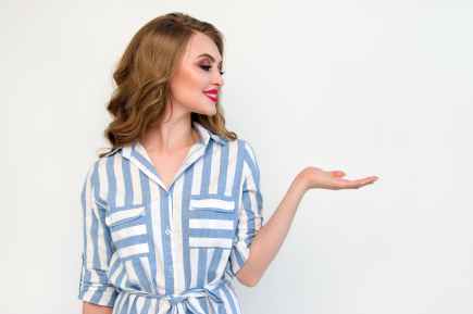 woman in blue and white striped top raising her left hand